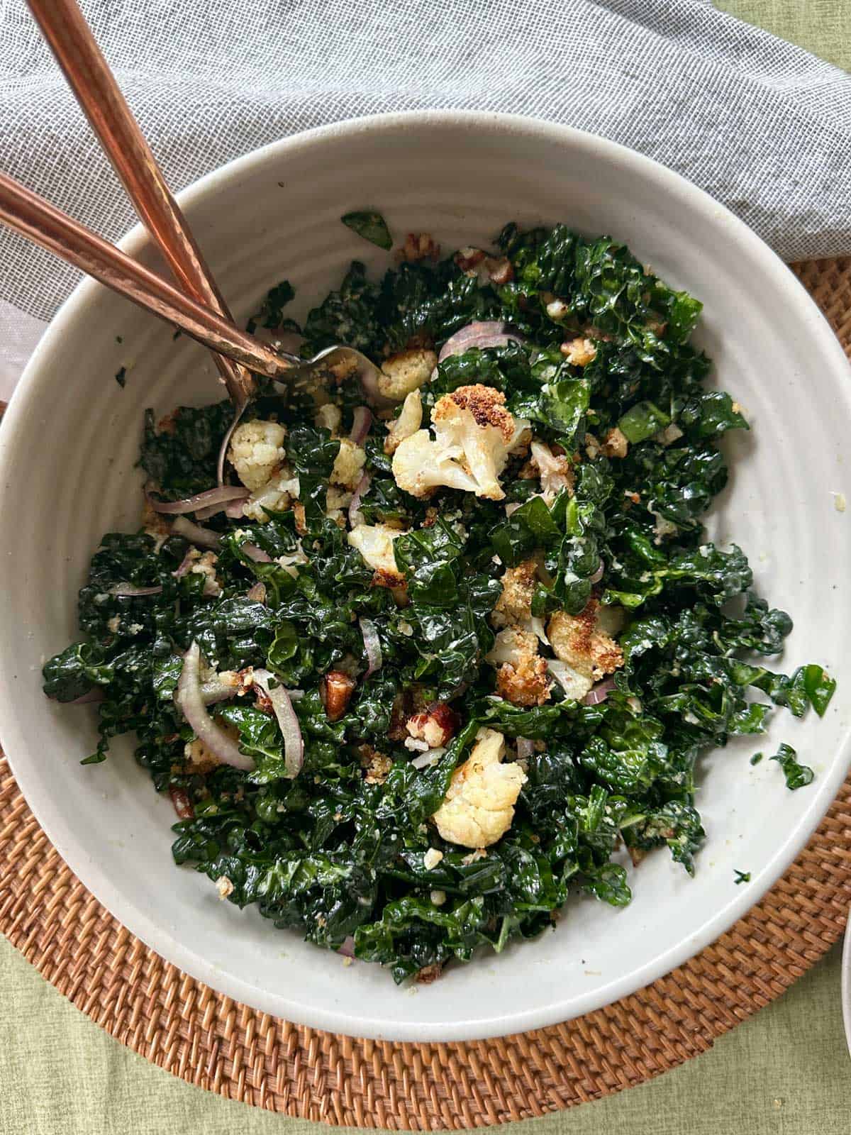 Crispy Cauliflower & Kale Salad in a bowl with a fork and spoon.