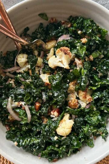Crispy Cauliflower & Kale Salad in a bowl with a fork and spoon.