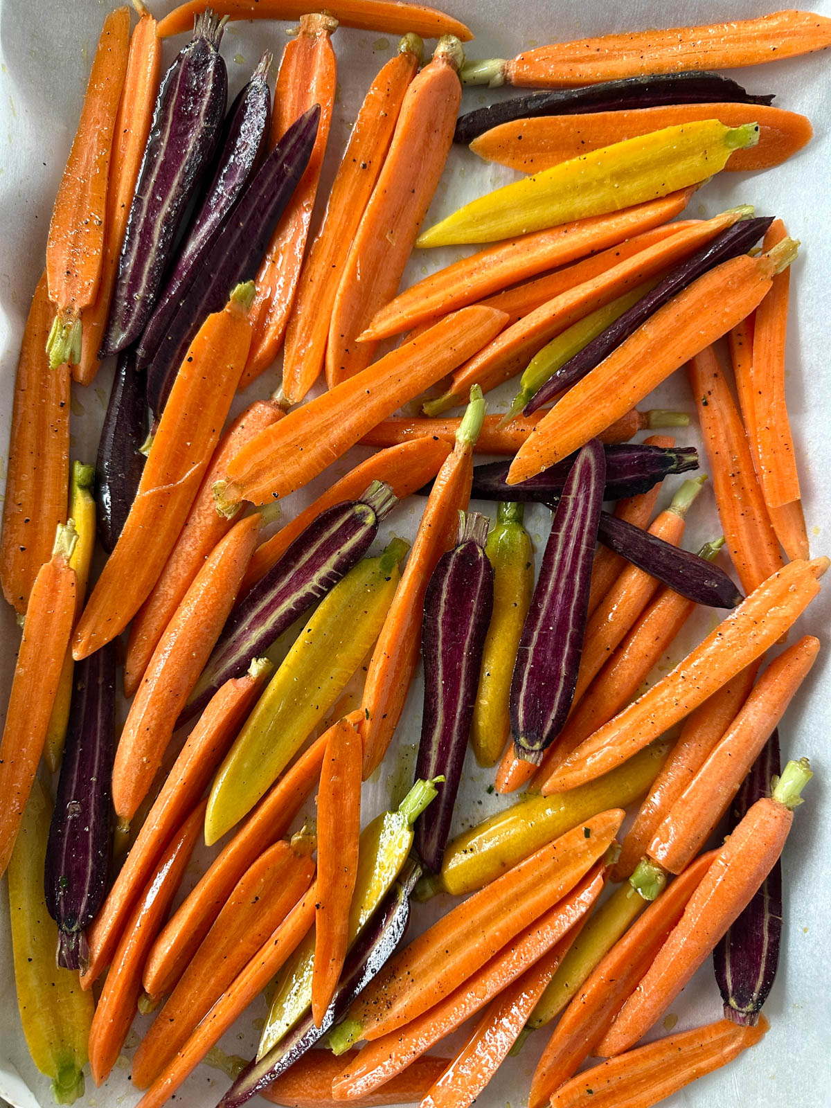 Carrots are prepped on a baking sheet lined with parchment paper.